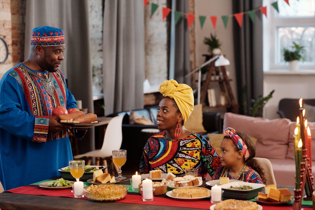 Festive family celebrating Kwanzaa with a traditional feast and colorful clothing.